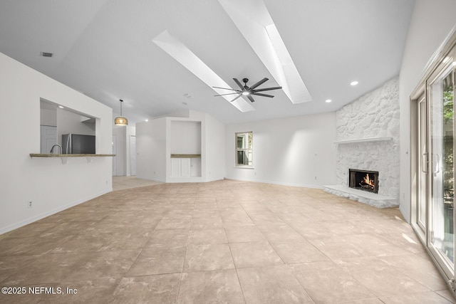 unfurnished living room with visible vents, a fireplace, ceiling fan, recessed lighting, and a skylight
