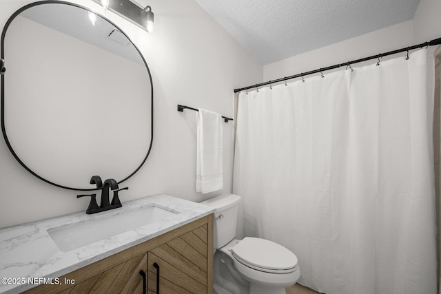full bathroom featuring vanity, toilet, and a textured ceiling