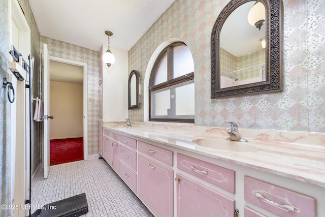 bathroom with wallpapered walls, double vanity, tile patterned flooring, and a sink