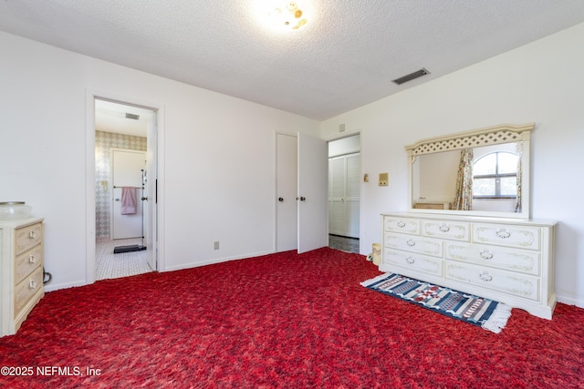 carpeted bedroom featuring ensuite bath, visible vents, and a textured ceiling