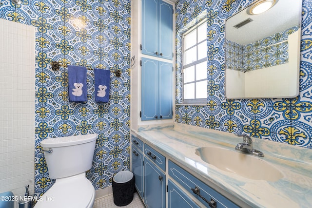 bathroom featuring visible vents, toilet, and vanity