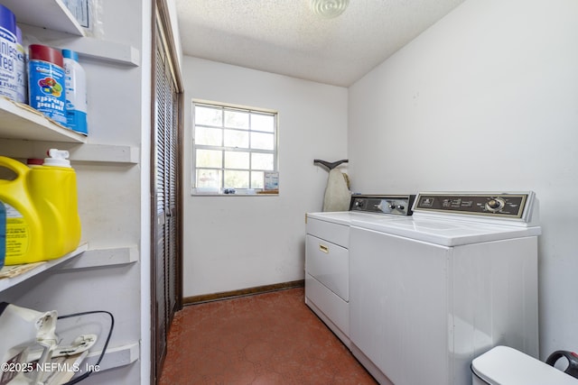 clothes washing area featuring baseboards, a textured ceiling, independent washer and dryer, and laundry area