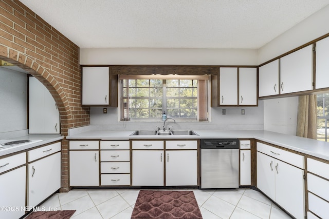 kitchen featuring stainless steel dishwasher, light countertops, a textured ceiling, and a sink
