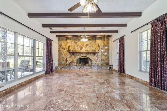 unfurnished living room with a textured ceiling, a stone fireplace, marble finish floor, and ceiling fan