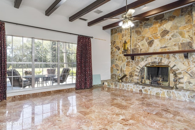 unfurnished living room with a stone fireplace, beam ceiling, and ceiling fan