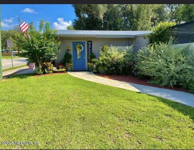 view of front of property featuring a front yard and metal roof