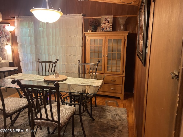 dining space featuring wood walls and wood finished floors