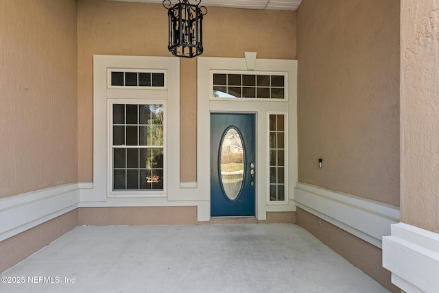 doorway to property featuring stucco siding