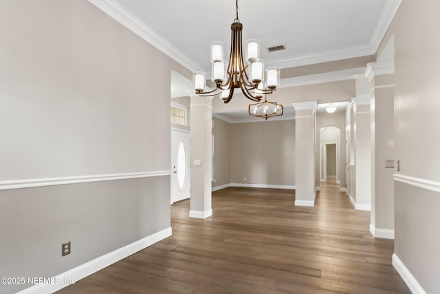 unfurnished dining area with a notable chandelier, crown molding, wood finished floors, baseboards, and visible vents