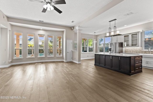 kitchen with hardwood / wood-style floors, light countertops, stainless steel refrigerator with ice dispenser, and a ceiling fan