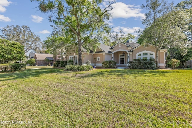 view of front facade with a front yard, stucco siding, and french doors