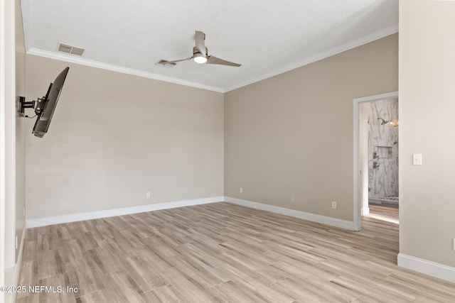 spare room with visible vents, light wood-style flooring, baseboards, ceiling fan, and ornamental molding