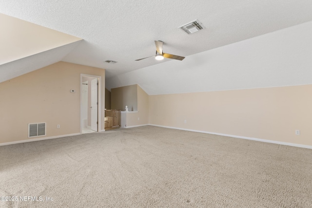 additional living space with a ceiling fan, a textured ceiling, and visible vents