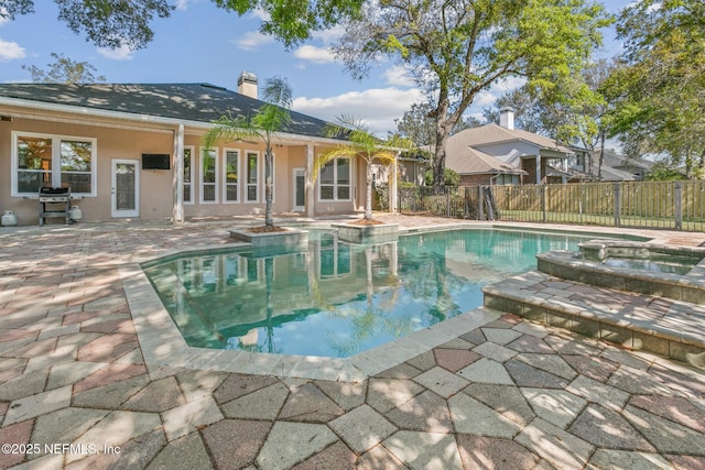 view of pool with a patio, a grill, fence, and a pool with connected hot tub
