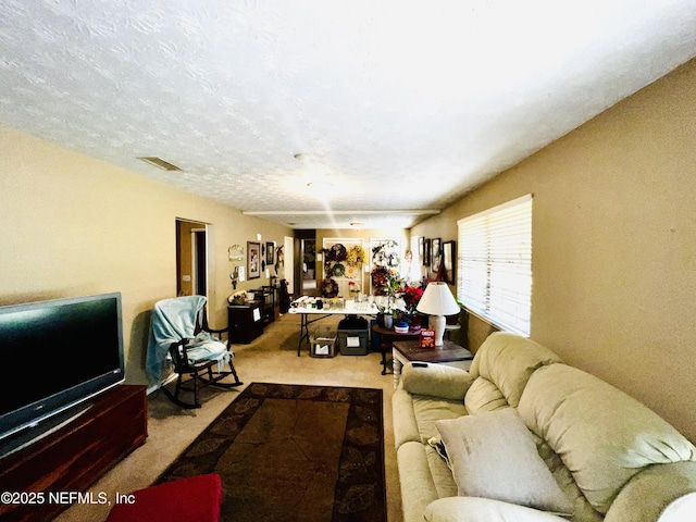 carpeted living area featuring visible vents and a textured ceiling