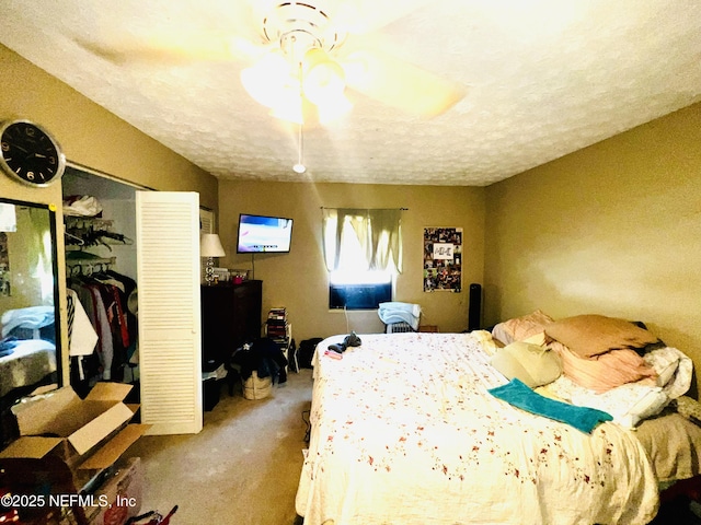 bedroom with a closet, a textured ceiling, a ceiling fan, and carpet floors