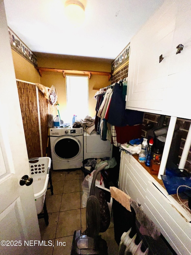 clothes washing area featuring tile patterned flooring, cabinet space, and independent washer and dryer