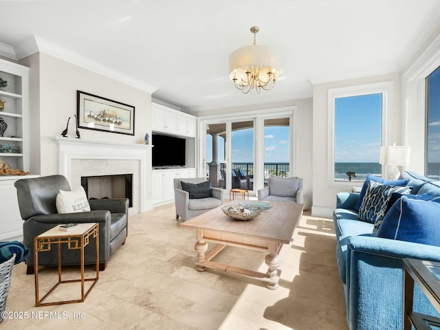 living area with a notable chandelier, a fireplace, built in shelves, and ornamental molding