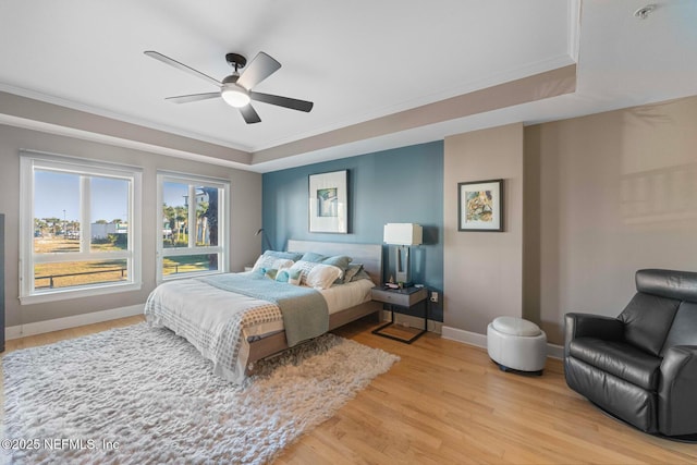 525 3rd St N Unit 210, Jacksonville Beach, FL 32250 - bedroom featuring a ceiling fan, baseboards, a tray ceiling, light wood-style flooring, and crown molding