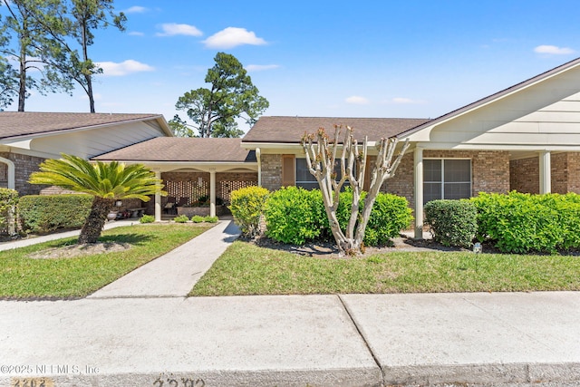 view of front of house with brick siding and a front yard