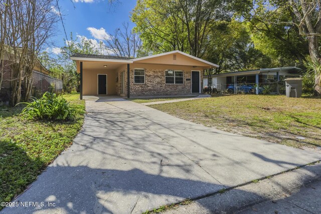 2108 W 15th St, Jacksonville, FL 32209 - view of front of property featuring stucco siding, a front lawn, driveway, an attached carport, and brick siding