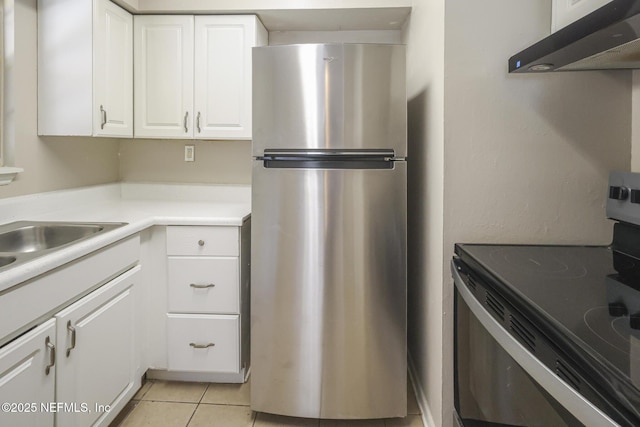 2108 W 15th St, Jacksonville, FL 32209 - kitchen featuring under cabinet range hood, stainless steel appliances, white cabinets, light countertops, and light tile patterned floors