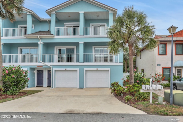 2114 Gail Ave Unit A, Jacksonville Beach, FL 32250 - view of front facade with a garage, a balcony, concrete driveway, and stucco siding