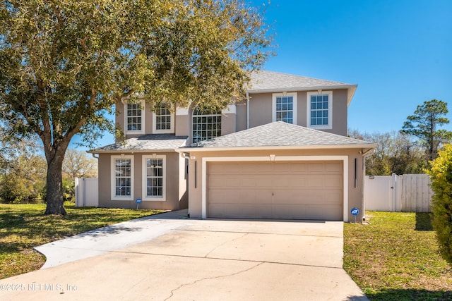 11 Reeding Ridge Dr W, Jacksonville, FL 32225 - traditional-style house with stucco siding, a front lawn, driveway, fence, and a garage