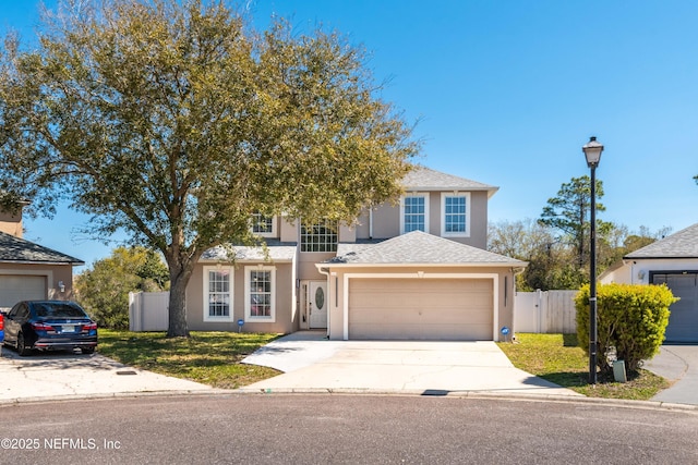 11 Reeding Ridge Dr W, Jacksonville, FL 32225 - view of front of property featuring an attached garage, fence, driveway, and stucco siding