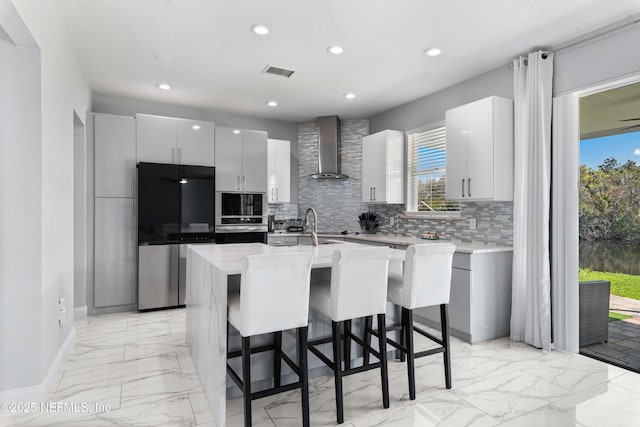 11 Reeding Ridge Dr W, Jacksonville, FL 32225 - kitchen featuring tasteful backsplash, visible vents, stainless steel appliances, and wall chimney exhaust hood