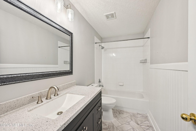 bathroom with visible vents, toilet, vanity, marble finish floor, and a textured ceiling