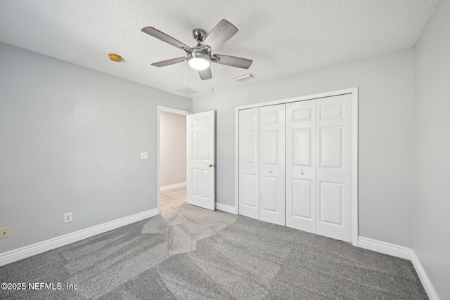 unfurnished bedroom featuring carpet flooring, baseboards, visible vents, and a closet