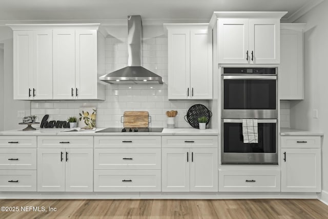 85172 Southern Creek Blvd, Fernandina Beach, FL 32034 - kitchen featuring light countertops, black electric cooktop, wall chimney exhaust hood, and double oven