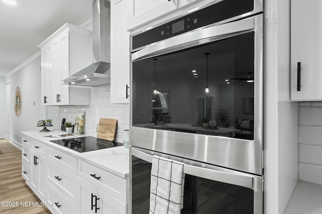 85172 Southern Creek Blvd, Fernandina Beach, FL 32034 - kitchen featuring stainless steel double oven, black electric stovetop, wall chimney exhaust hood, decorative backsplash, and ornamental molding