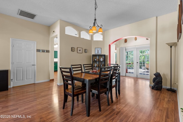 5266 Camelot Forest Dr, Jacksonville, FL 32258 - dining space featuring french doors, visible vents, arched walkways, and wood finished floors