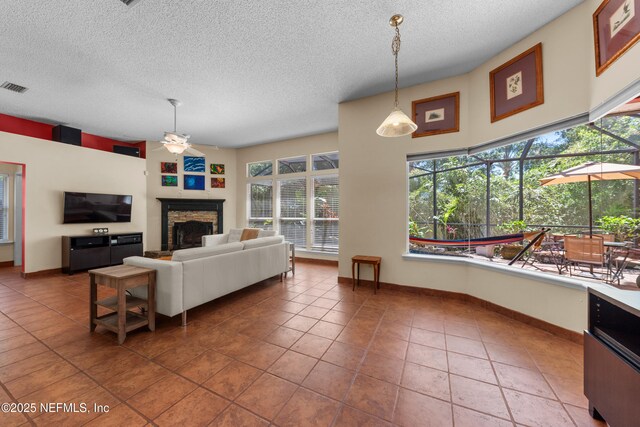 5266 Camelot Forest Dr, Jacksonville, FL 32258 - tiled living room featuring a fireplace, a textured ceiling, visible vents, ceiling fan, and a sunroom
