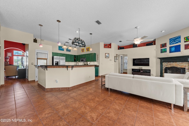 5266 Camelot Forest Dr, Jacksonville, FL 32258 - living area featuring visible vents, a stone fireplace, a ceiling fan, a textured ceiling, and tile patterned floors
