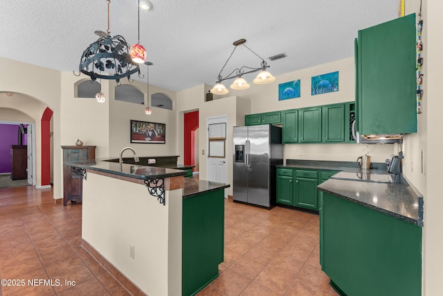 5266 Camelot Forest Dr, Jacksonville, FL 32258 - kitchen featuring visible vents, arched walkways, stainless steel fridge, dark countertops, and green cabinets