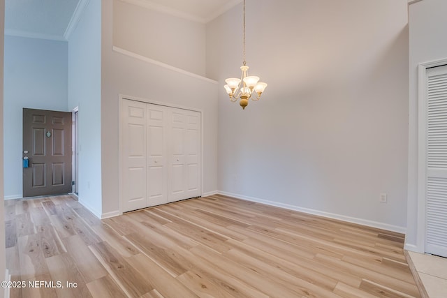 1601 Nectarine St Unit D5, Fernandina Beach, FL 32034 - unfurnished dining area with a towering ceiling, a notable chandelier, and crown molding