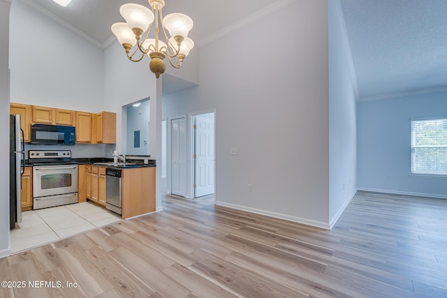 1601 Nectarine St Unit D5, Fernandina Beach, FL 32034 - kitchen with high vaulted ceiling, dark countertops, crown molding, stainless steel appliances, and a notable chandelier