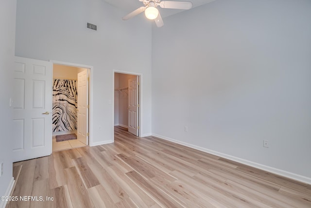 1601 Nectarine St Unit D5, Fernandina Beach, FL 32034 - unfurnished bedroom featuring a walk in closet, a high ceiling, light wood-type flooring, baseboards, and visible vents