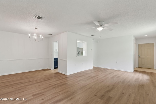 13706 Wm Davis Pkwy, Jacksonville, FL 32224 - unfurnished living room with a chandelier, a textured ceiling, light wood-type flooring, and a ceiling fan