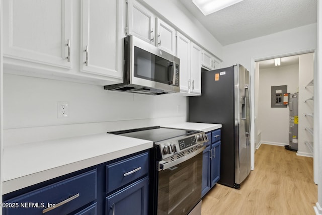 13706 Wm Davis Pkwy, Jacksonville, FL 32224 - kitchen with stainless steel appliances, blue cabinetry, light wood-type flooring, electric water heater, and white cabinetry