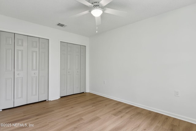 13706 Wm Davis Pkwy, Jacksonville, FL 32224 - unfurnished bedroom featuring two closets, light wood finished floors, and ceiling fan