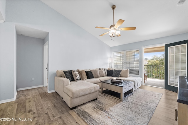 living room with baseboards, high vaulted ceiling, a ceiling fan, and wood finished floors