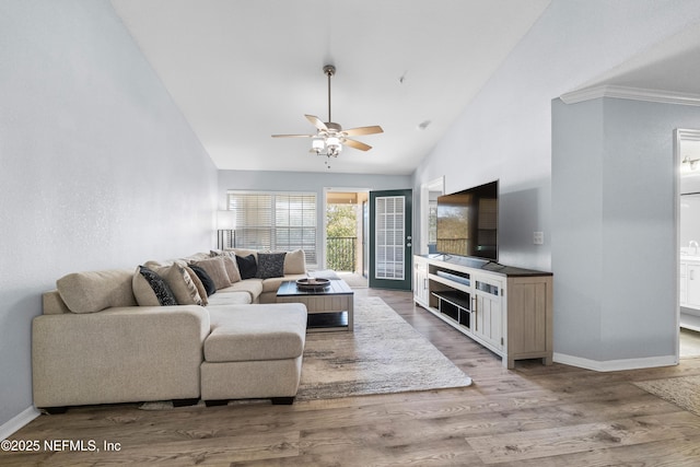 living area featuring baseboards, wood finished floors, high vaulted ceiling, and ceiling fan