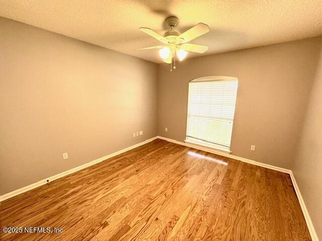 2924 Captiva Bluff Rd S, Jacksonville, FL 32226 - unfurnished room featuring a ceiling fan, a textured ceiling, baseboards, and wood finished floors