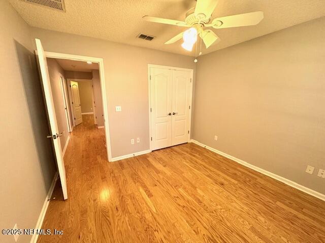 2924 Captiva Bluff Rd S, Jacksonville, FL 32226 - unfurnished bedroom with visible vents, a textured ceiling, baseboards, and light wood-type flooring