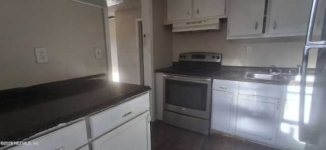 kitchen featuring under cabinet range hood, a sink, dark countertops, stainless steel range with electric cooktop, and white cabinets
