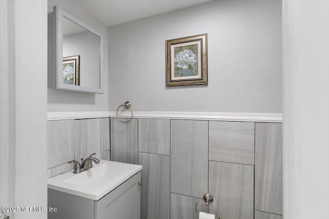 bathroom with vanity and a wainscoted wall